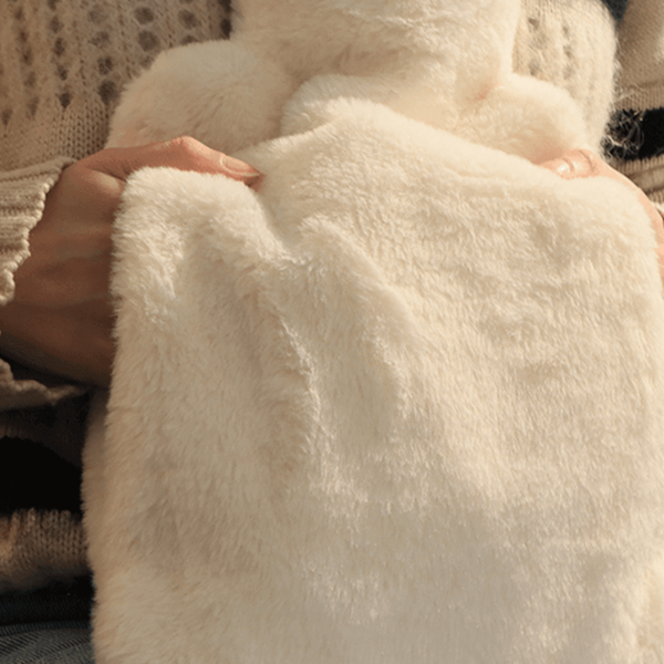 Pouchy-Faux-Fur-Hot-Water-Bottle-in-white-lifestyle-hand-pouch